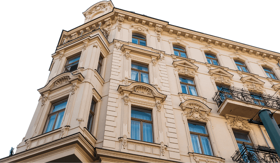 Historisches Gebäude mit dekorativen Ornamenten und Fenstern in der Fassade, aufgenommen aus einem niedrigen Blickwinkel.